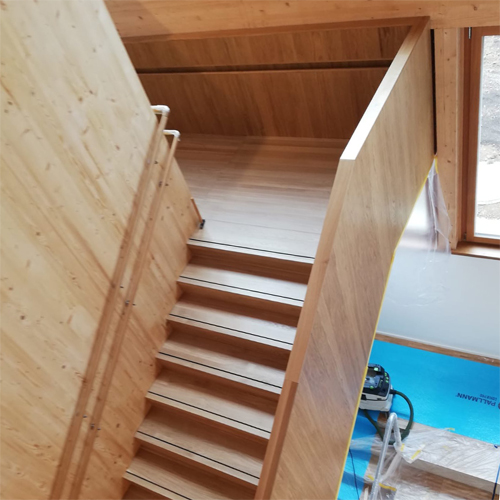 Holztreppe mit Treppenlauf und Antirutschschiene auf den Stufen