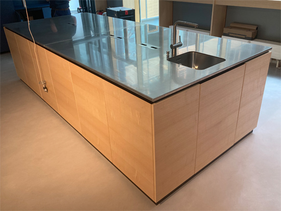 Objekteinrichtung Showkche Vollkernarbeitsplatte, eingefrstes Waschbecken rckseitig verklebt, Mllkipper aus Aluminium, Arbeitsplatte aus Edelstahl mit Kabelausschnitten