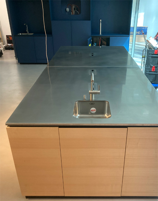 Objekteinrichtung Showkche Vollkernarbeitsplatte, eingefrstes Waschbecken rckseitig verklebt, Mllkipper aus Aluminium, Arbeitsplatte aus Edelstahl mit Kabelausschnitten